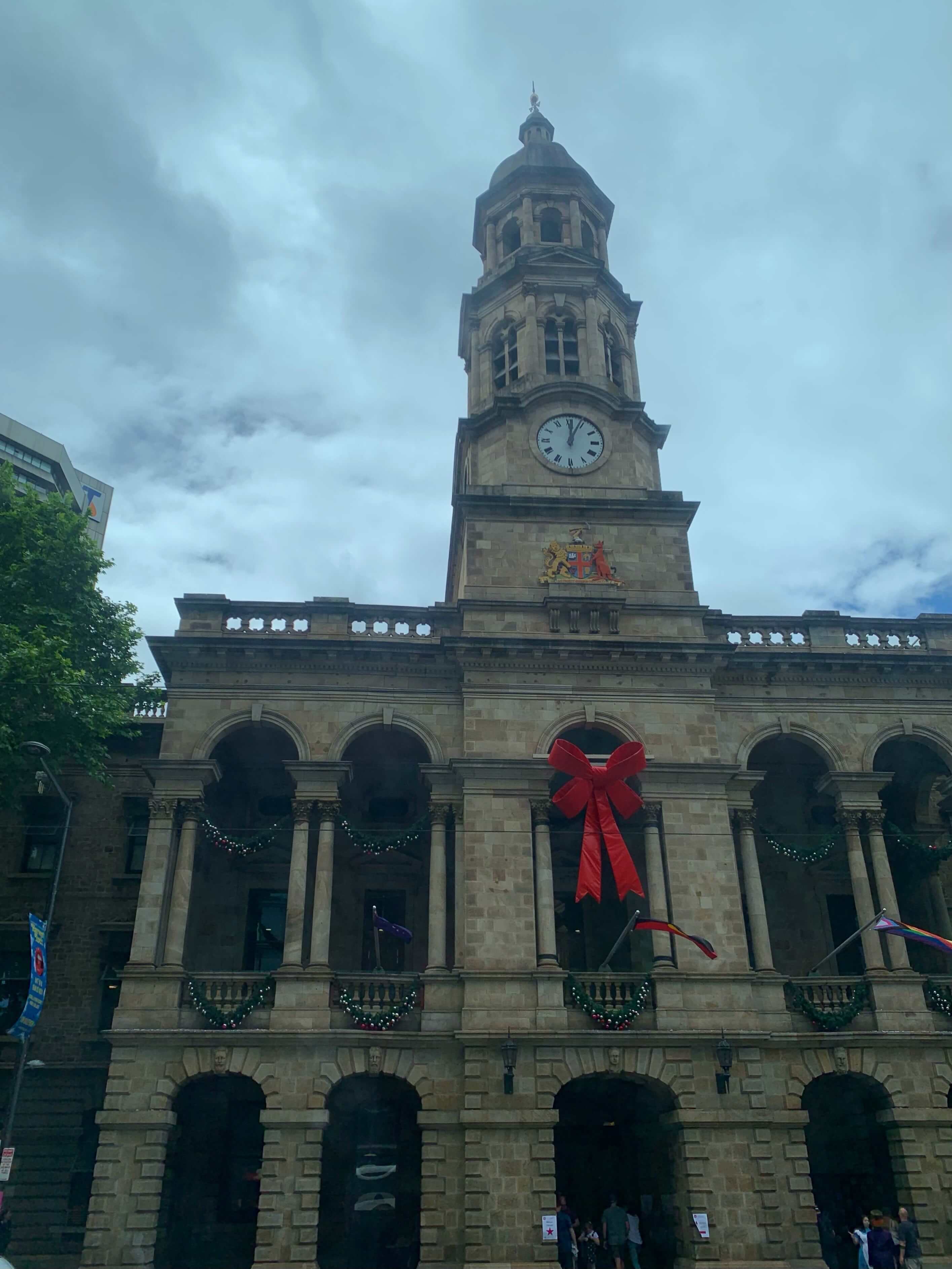 Photo of the Adelaide Town hall, with a giant red bow on its facade
