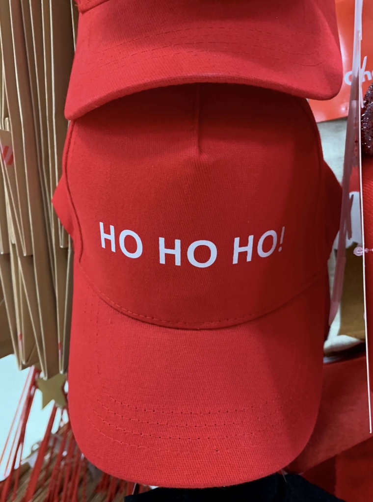 Close up photo of a red cap on a store with the words, “Ho, Ho, Ho!”